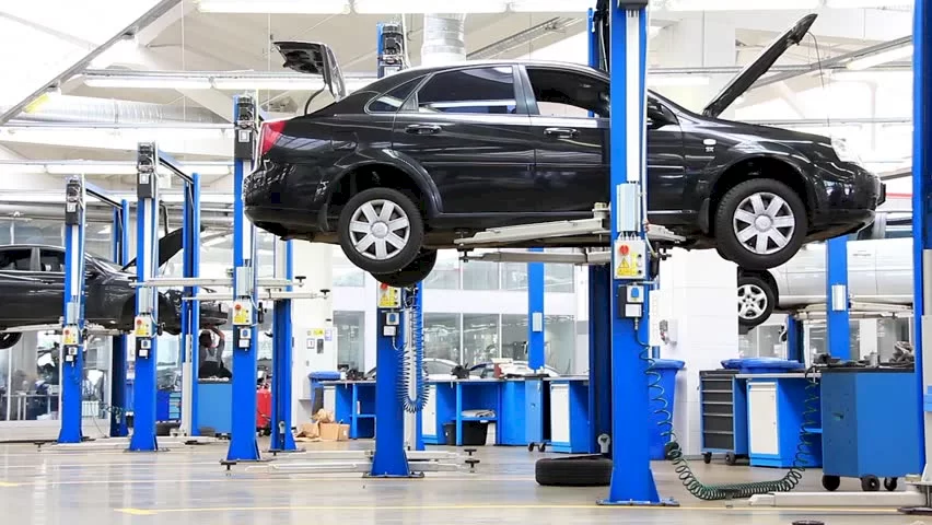 Servis atölyesinde araç üzerinde çalışan teknisyenler
